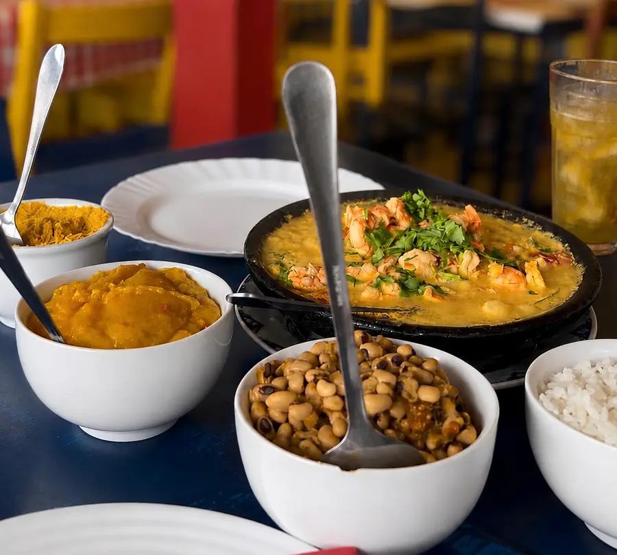 Moqueca and Bahian side dishes on a restaurant table